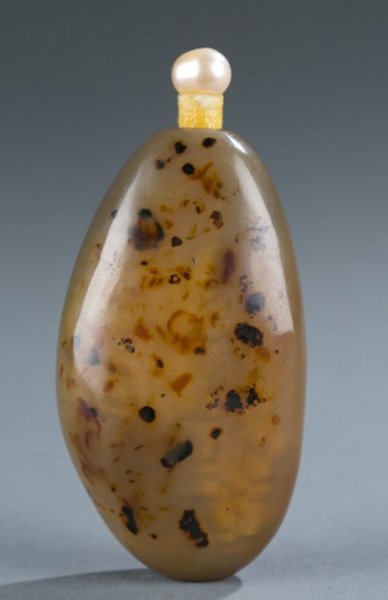 Pebble shadow agate snuff bottle, 1860-1910.: A free form shadow age pebble snuff bottle. c.1860-1910. With many black and brown inclusions. Nature pearl top and ivory spoon. 2 3/4"h.