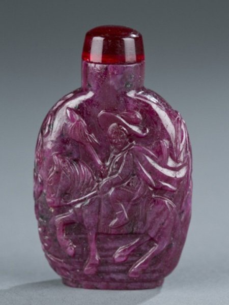 20th c Chinese Ruby Matrix Snuff Bottle: A Chinese ruby matrix snuff bottle. 20th century. Of rounded rectangular form with a relief carved figure on horseback and a pine tree. 2 1/4" h.