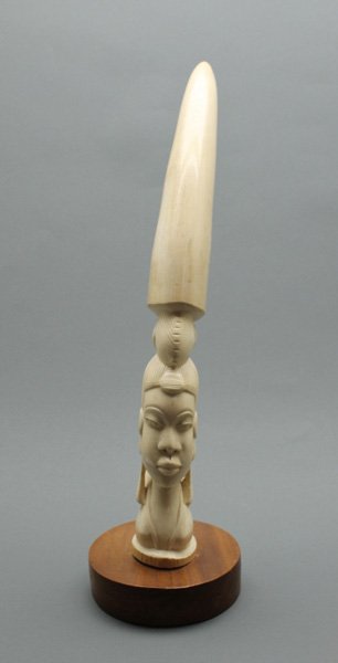African elephant ivory bust of maiden.: Mounted on wood plinth. Tusk 19 1/2"l.