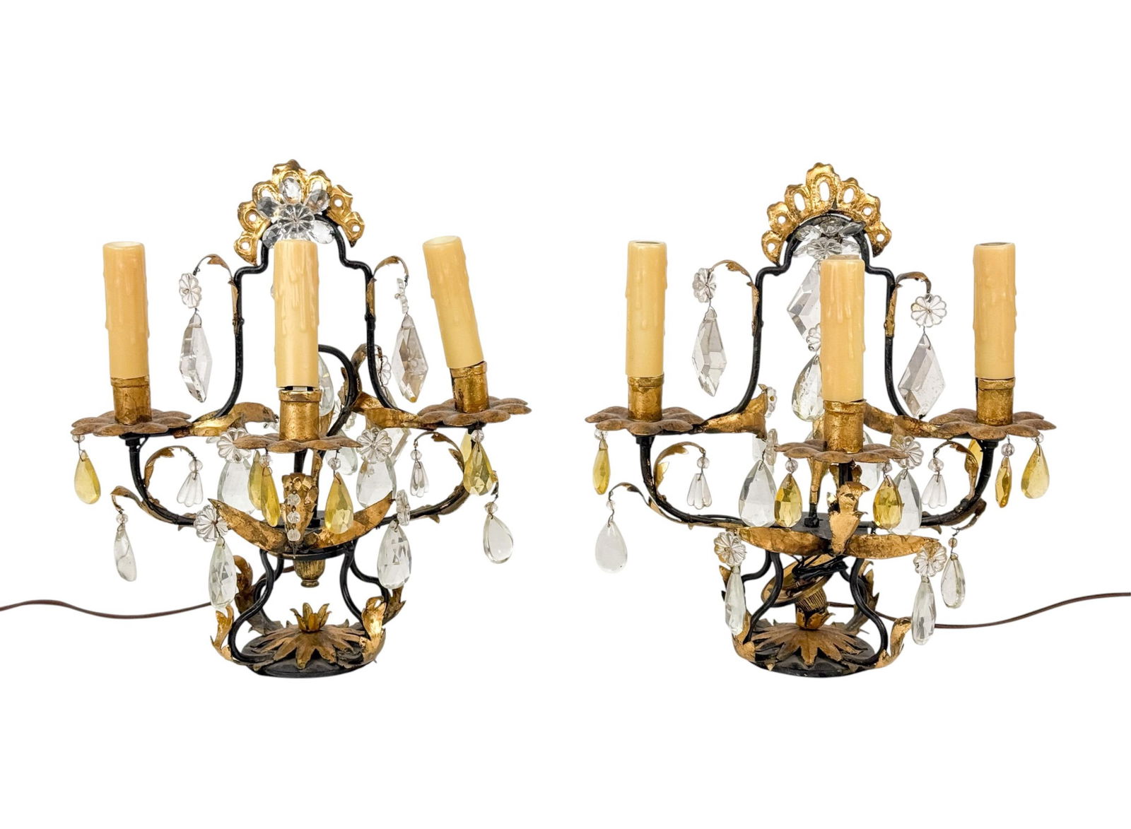 2 French gilt metal and crystal table lamps.: Pair of French gilt metal and crystal three-light table lamps, 20th Century. Each lamp with scrolling foliate arms supporting faux candle sockets, hung throughout with faceted crystal prisms and drops
