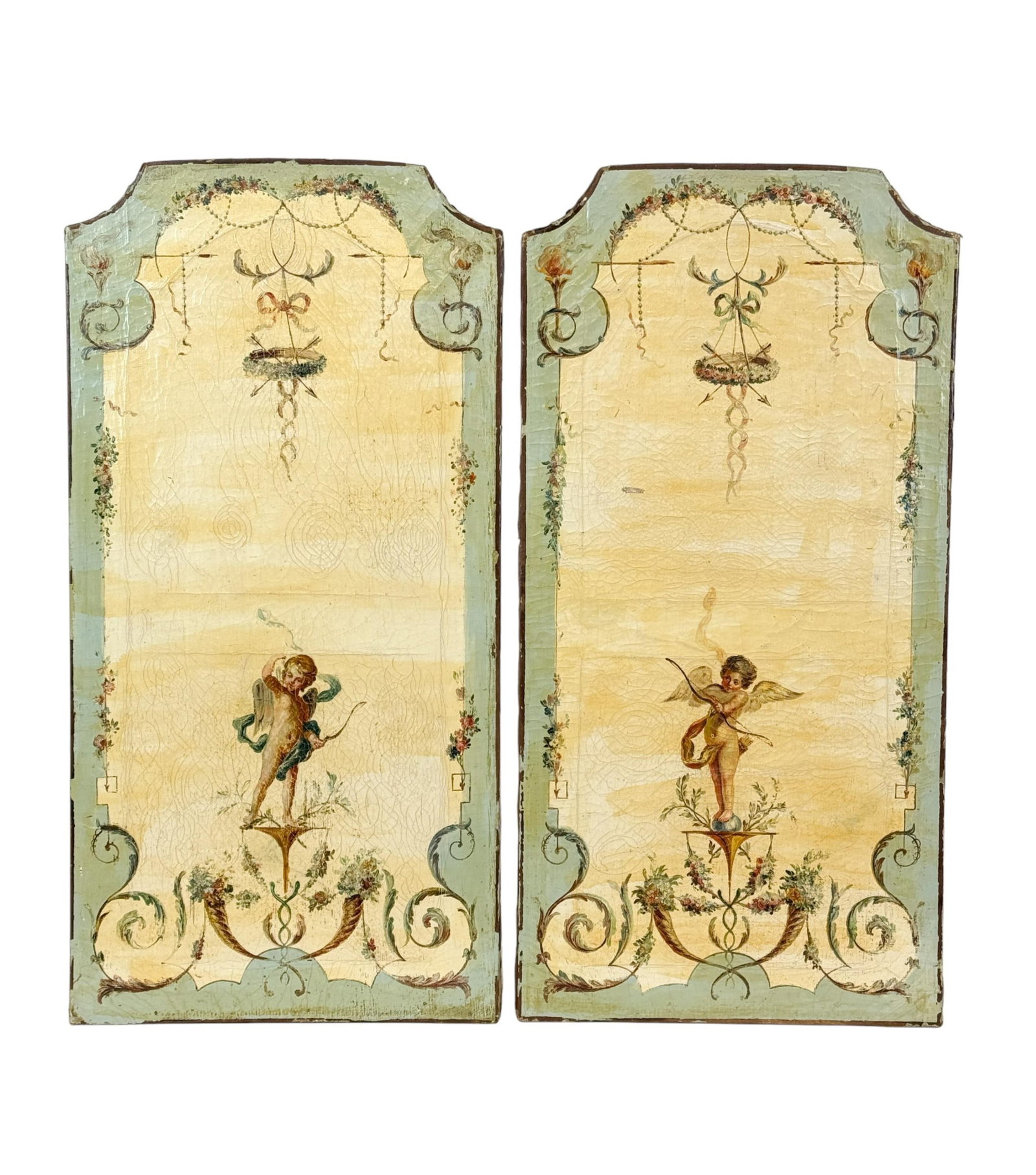 Pair of French decorative paintings, 19th c.: A pair of French decorative paintings. Oil on canvas. 19th century. Depicting winged putti holding bows and arrows within scrolling floral ornament and neoclassical garland motifs. Having shaped, roun