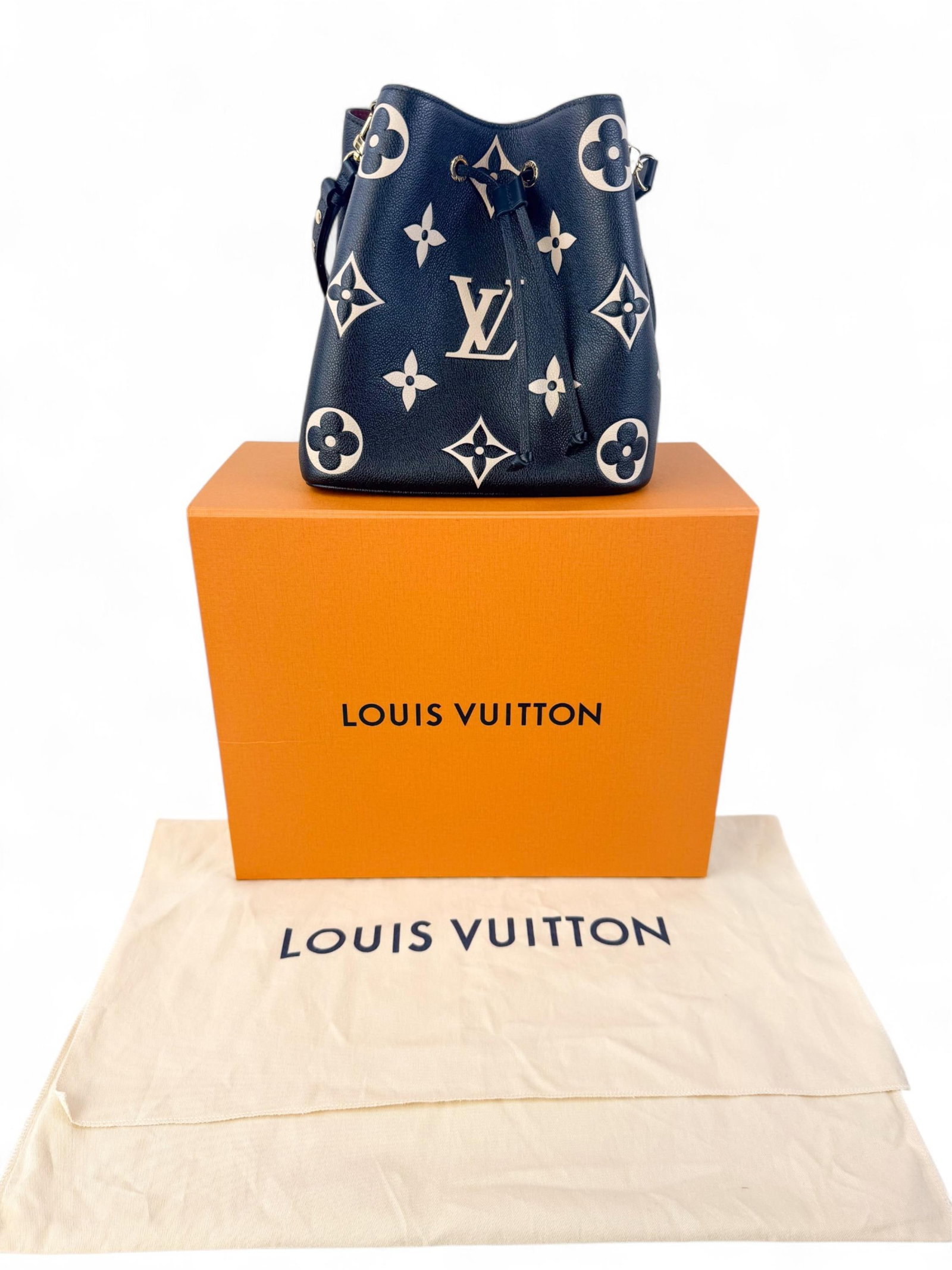 Louis Vuitton monogram Empreinte NeoNo? bucket bag: A black Louis Vuitton Empreinte leather bucket bag with cream monogram, gold-tone eyelet drawstring closure, and adjustable shoulder strap. Includes original box.