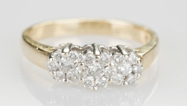 Diamond cluster ring 3/4ct: A 14KT yellow gold ring with nineteen diamonds prong set into three flower like clusters with an estimated 0.75 TCW. Marked "14kt".Size 7.Tw. 0.115 ozt. Condition: Some stones are abraded on the girdl