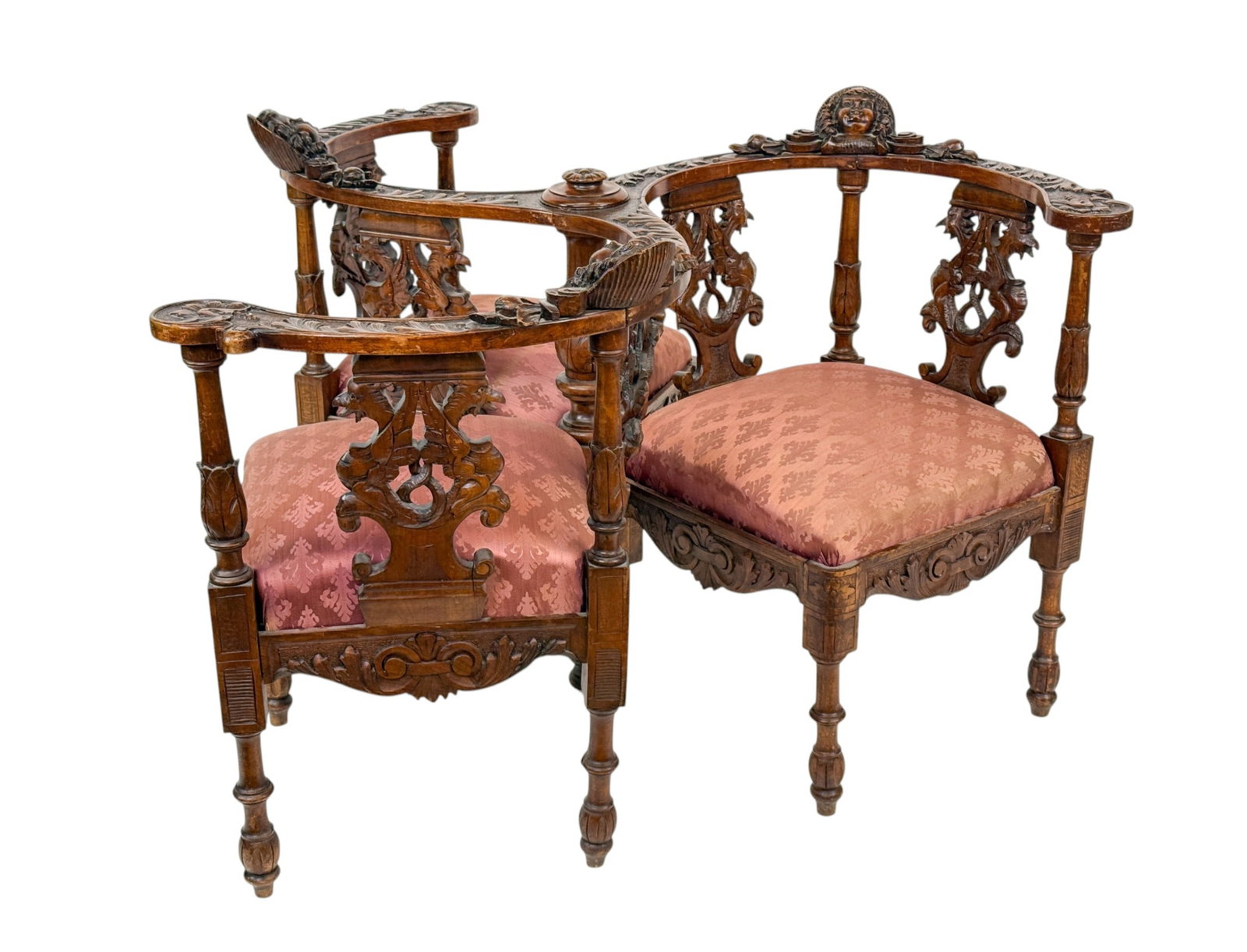 Victorian tete-a-tete conversation chair.: A Victorian tete-a-tete three seat conversation chair. Craved wood with putti heads. 31" x 47" x 45".