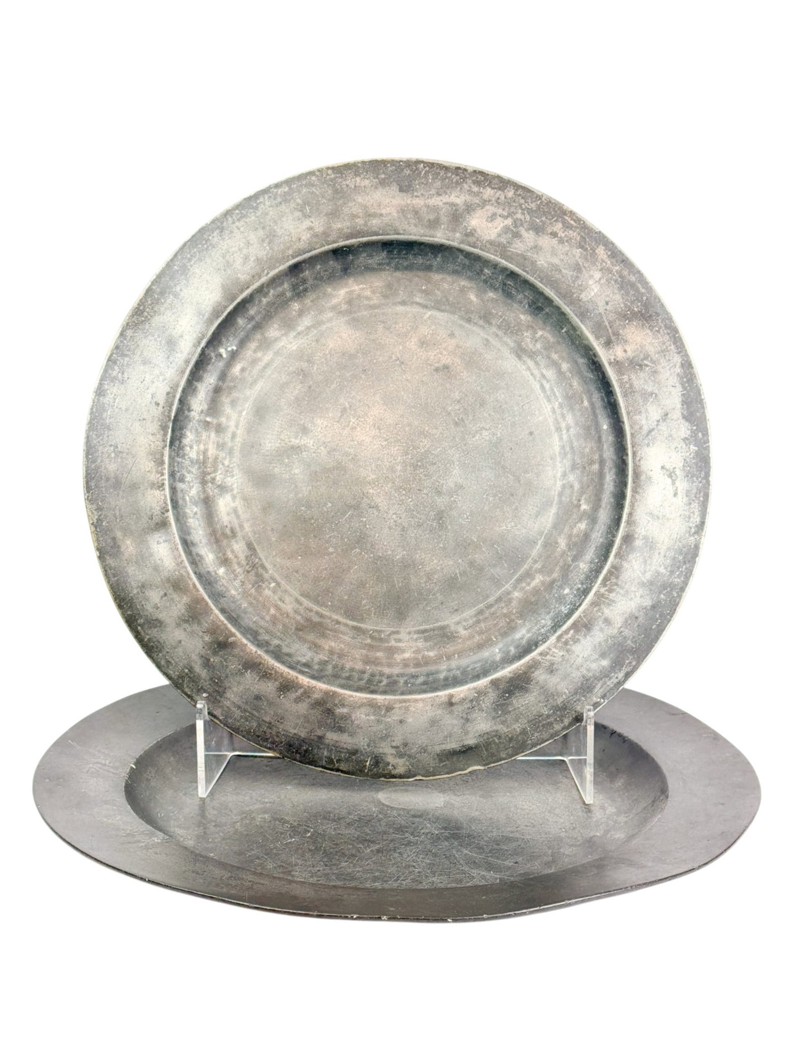 2 Large pewter chargers.: A group of two large pewter chargers. One has partial touchmarks. One has winged deer head amorial. Smallest: 16 1/2". Largest: 18".