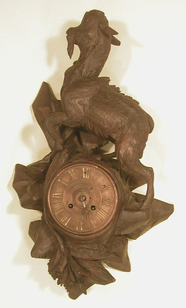 German Black Forest carved wall clock wi: German Black Forest carved wall clock with large goat wooden face with brass numerals, goat missing horns & 1 ear replaced, works marked LD 2988, 2nd half 19th century, 21"h x 12"w.