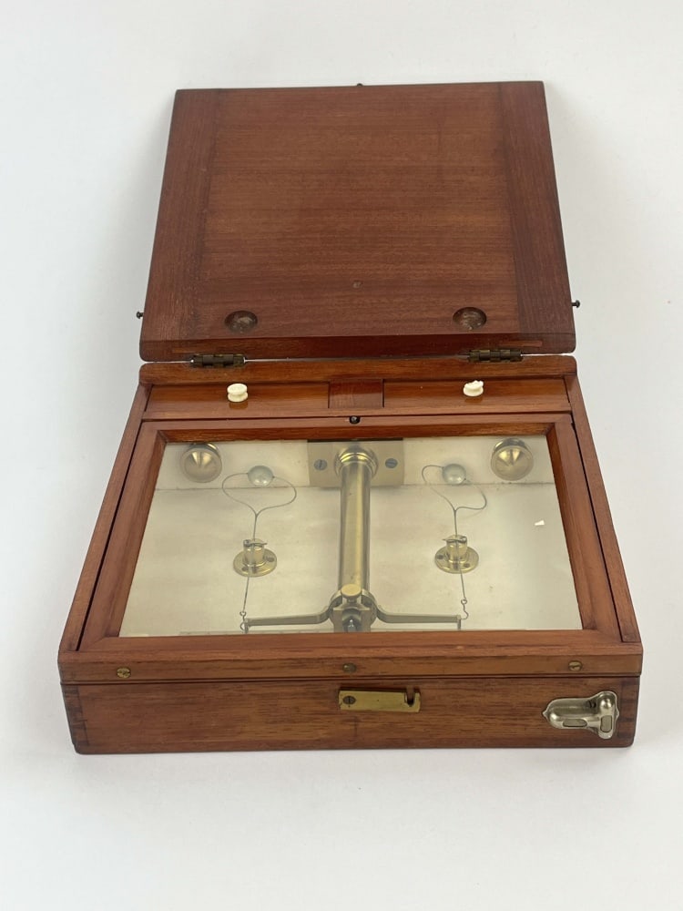 Late 19th/Early 20th Century Portable Assay or: Analytical Balance. A precision equal-arm balance mounted within a fitted mahogany traveling case, the instrument constructed in lacquered brass with graduated beam, fine wire pan suspensions and