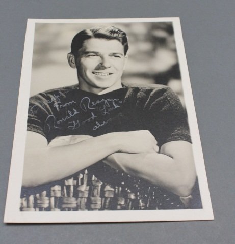 Ronald Reagan: Signed & inscribed, while an actor.: [President Reagan, Ronald]. Signed and inscribed halftone photograph of Reagan during his acting career. Image: 6 ½” x 4 5/8”. 2 tiny adhesion remnants at upper corners of verso, otherwise near f