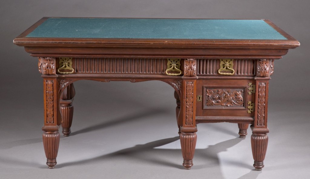 Victorian mahogany carved partner's desk.: A mahogany carved partner's desk with felt top. Late 19th century. Each side with 2 pass through drawers and 1 door, with brass hardware. 30"h x 58"w x 35 1/2"d.
