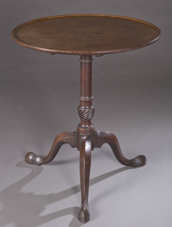 19th Century Chippendale tilt top tea table.: A Chippendale tilt top tea table. 2nd half of 19th century. Tilt top tea table with a turned pedestal on tripod with snake feet, and a dish top. Hand-forged hardware is present on underside of pedesta