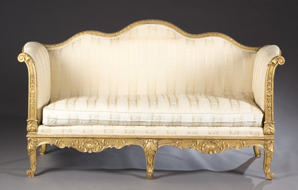 Pair of Louis XV style sofas.: A pair of Louis XV style settees. c.1920s-30s. High back with scrolling crest rail and high slightly rolled arms, skirt with 2 centered shell carvings, supported by legs with acanthus carved knees. 34