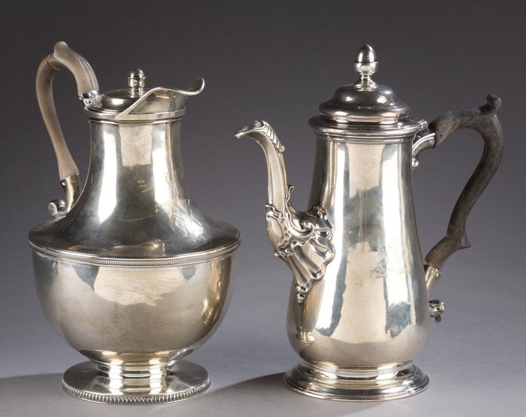 Two 19th Century London Sterling teapots.: A group of two London sterling hollowware pieces. ++ Hot water pot with a wide spout and a round body, engraving of a crest with stags. Hallmarked for 1804-05, makers mark TE over (?)S. 9"h. ++ Coffee