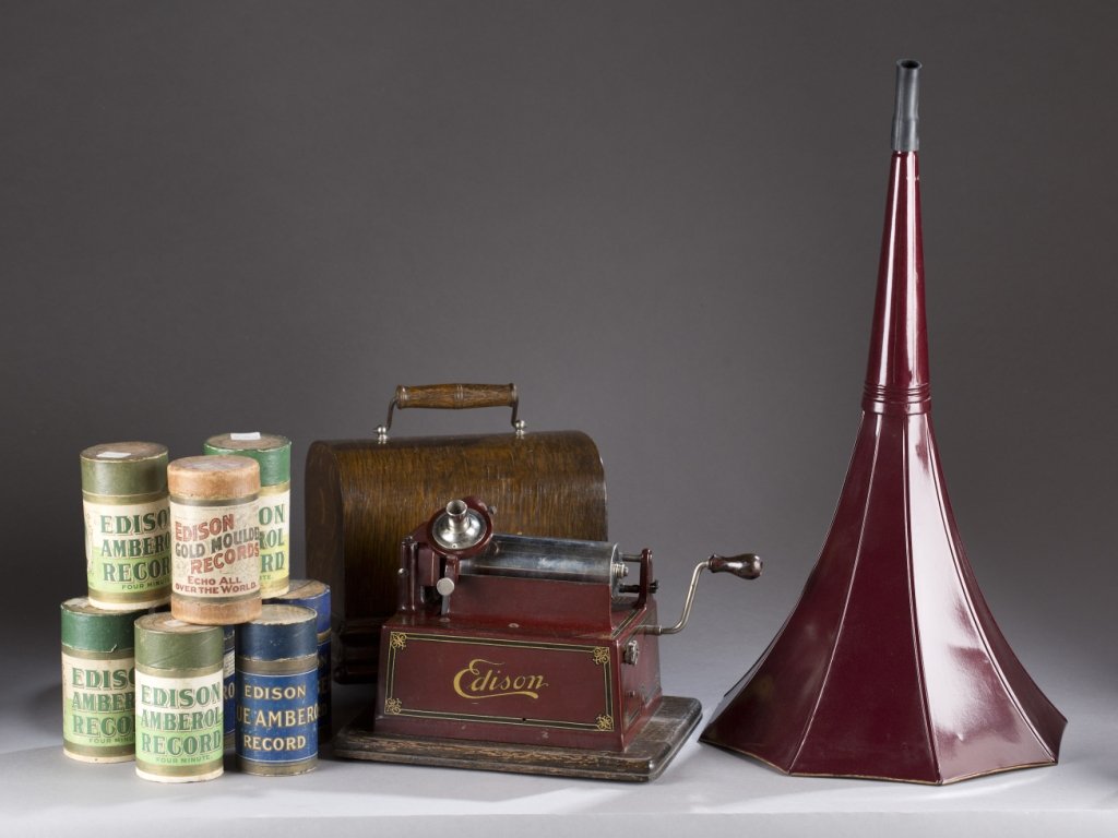 Edison Maroon Gem phonograph.: An Edison Gem cylinder phonograph, model D with oak case. c.1909-10. Includes baby morning glory maroon horn and 8 Edison amberol cylinders. Phonograph: 8"h x 8 1/2"w x 4 1/4"d. Horn: 21"h x 10 3/4"di