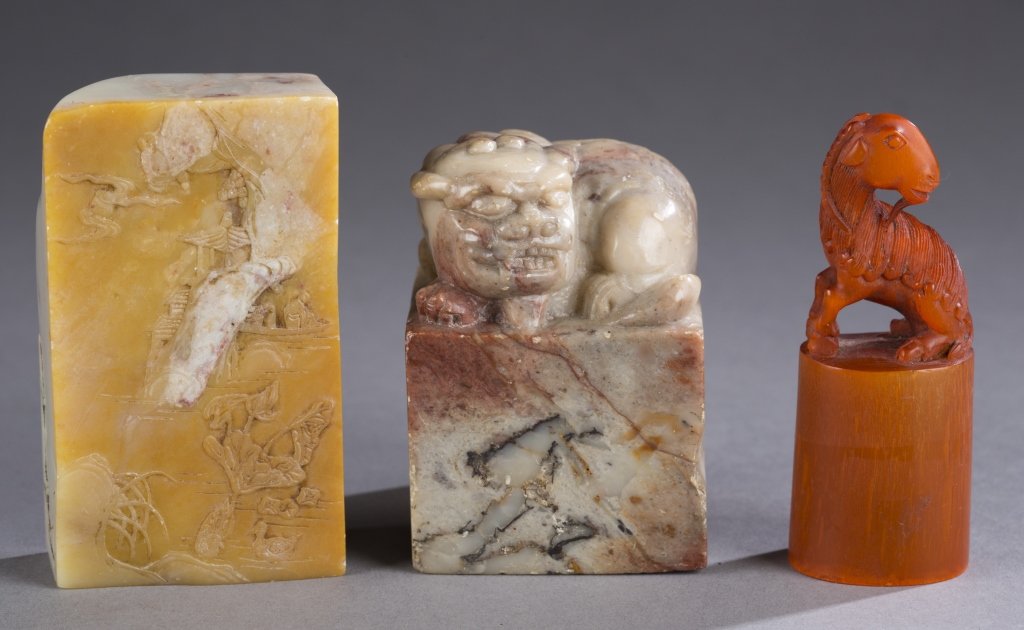 3 Chinese seals.: A group of three Chinese seals. 19th/20th century. ++ A soapstone seal having shallow relief carving of monks in outcrop and temple on verso. 3 1/8" x 13/4. ++A soapstone seal having carved Chinese li
