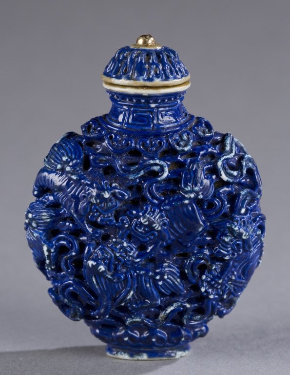 Porcelain blue glaze Buddhist Lions Snuff bottle.: A Chinese Jiaqing molded porcelain snuff bottle with blue glaze. c.1796-1820. Relief design of 9 Buddhist lions. 2 3/8"h Provenance: Ex of the Wise collection.