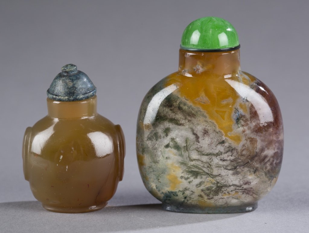 Moss agate and agate 19th century snuff bottles.: A group of 2 agate Chinese snuff bottles. 19th century. ++ A small agate bottle with raised panels on shoulders. well hollowed. 1 5/8"h. ++ A moss agate bottle of rounded rectangular form. Well hollow