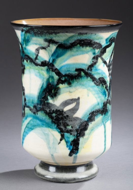 A Cowan Pottery hand painted footed vase with yellow,: A Cowan Pottery hand painted footed vase with yellow, blue, green, and black glaze. c. 1930. Impressed Cowan mark on bottom. 8 1/4"h x 6"w.
