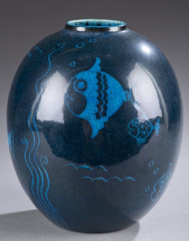 A Cowan pottery dry point decorated fish vase by: A Cowan pottery dry point decorated fish vase by Viktor Schreckengost. c. 1931. V-91. Blue over black glaze. Having impressed Cowan mark on bottom. 6 1/2"h x 2"w.