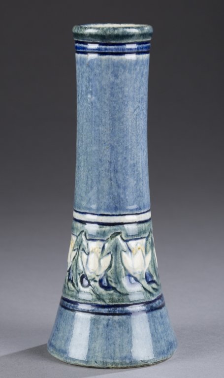 A Newcomb College bud vase, decorator Marie De Hoa: A Newcomb College bud vase, decorator Marie De Hoa LeBlanc and potter Joseph Meyers. c.1907. White clay body with blue, green and yellow glossy glaze with daffodil decoration. Impressed on bottom NC, 