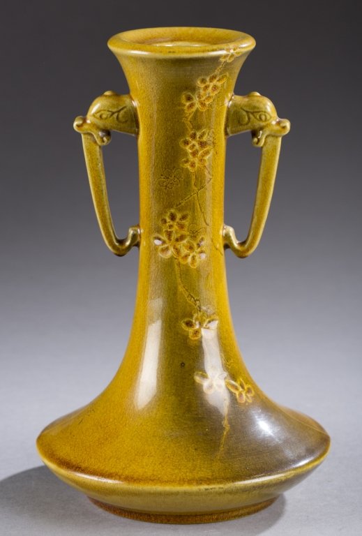 A Rookwood pair of production vessels. ++ Two handled: A Rookwood pair of production vessels. ++ Two handled candlestick with cherry blossom design and dragon heads. Impressed on bottom, Rookwood 1885, 37, S, 6 and artist mark (AMB). 8 1/4". ++ Nut dish w