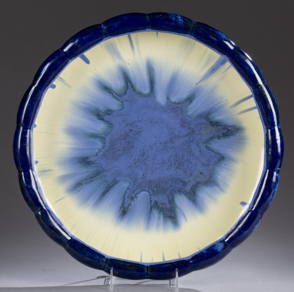 A Fulper Pottery large bowl. A large bowl with a: A Fulper Pottery large bowl. A large bowl with a scalloped and folder over rim in dark blue glaze. Inside of bowl is yellow and blue glazes with the center decorated with iridescent blue glaze. The bo