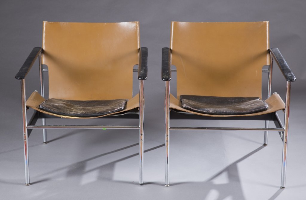 A pair of Pollock model 657 chairs.: A pair of Charles Pollock Model 657 Sling Chairs. 2nd half 20th century. Brown leather with black leather seat cushions and chrome frames. Original Knoll sticker on one chair. 29"h x 25"w x 26"d. The