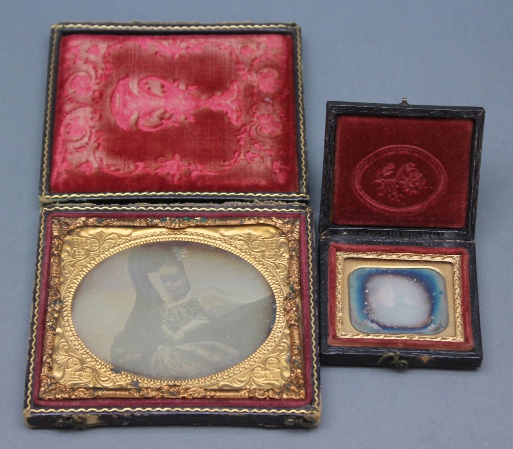 2 Post-Mortem/Memento Mori Daguerreotypes.: [Daguerreotypes/Mourning]. 2 Post-Mortem or Memento Mori Daguerreotypes.++ Sixth-plate (2 3/4" x 3 1/4") daguerreotype of a deceased young girl posed on a sofa holding a book, in a full leather case w