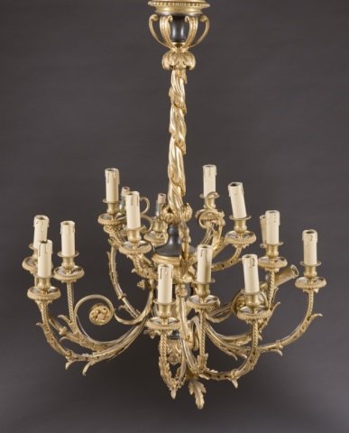 Gilded chandelier.: A Victorian style fifteen light chandelier. 20th century. Gilded appendages support faux candle lighting with wrapped central support made to look like draped fabric.