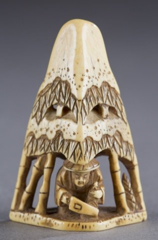 A Japanese ivory netsuke of a man cutting bamboo.: A Japanese ivory netsuke of a man cutting bamboo. c.1800. Man with cutting tool under a snow capped canopy of bamboo, triangular form. 6.6cm h. Purchased from Kyoto Art Club, 1962. Provenance: The Hum