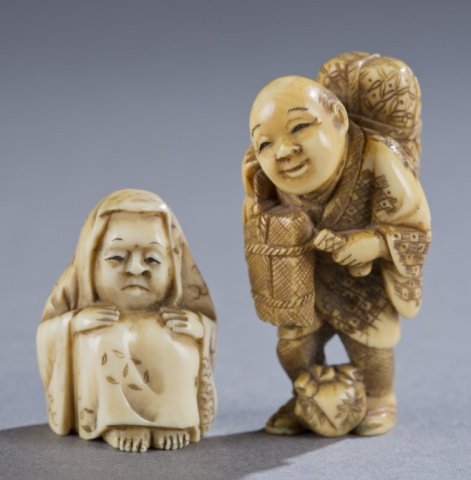 Two Japanese ivory netsuke – Daruma & man.: Two Japanese ivory netsuke. 19th century. ++ A seated Daruma with hands on knees. Small himotoshi on bottom. 3cm. ++ A standing gentleman with packages over shoulders and sack at feet. Signed on botto