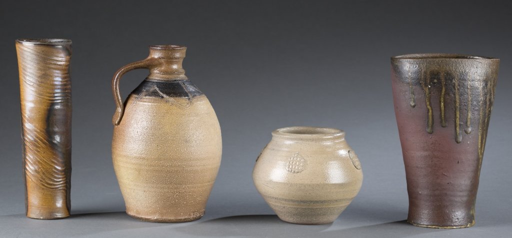 Group of 5 pieces of art pottery.: A group of 5 pieces of art pottery. 20th century. ++ Cylindrical vase with a scored wave design in various brown glazes. Marked on the side with a diamond and a line through it. 8 3/8". ++ Handled jug