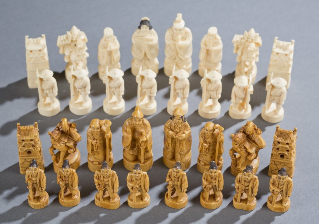 Japanese ivory chess set.: A Japanese ivory chess set. Late 19th/early 20th century. White and tobacco colored, with each opponents king and queen having marks on the bottom of the base. Comes in a wooden box that fold open to