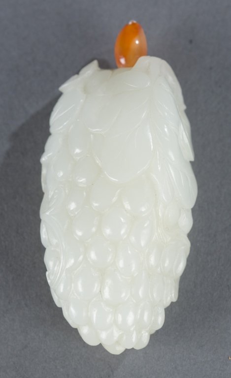 Chinese white jade snuff bottle - cluster of grap: A Chinese white jade cluster of grapes snuff bottle. c.1750-1850. Oblong form with grapes and leaves, with a small carnelian stopper. 2 1/2". Provenance: The Morrison Collection.