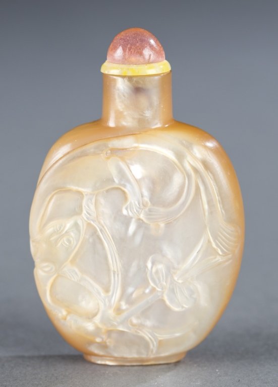 Mother of pearl Chinese snuff bottle.: A mother of pearl Chinese snuff bottle. c.1780-1850. A natural ovoid form with carved squirrels and vines, with a pink glass stopper. 2 3/8". Provenance: From a Private New York Collection.