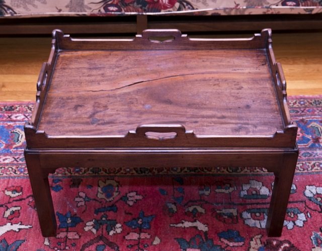 Hardwood tray table: A hardwood tray table with detachable tray. Has a crack through the center of the tray. 16 1/2"h x 28"w x 20"d.