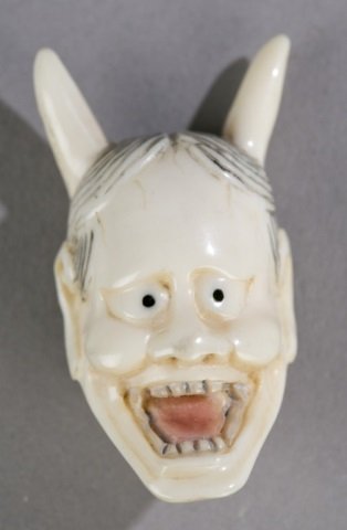 Pair of netsukes.: Pair of netsukes. Demon face. 1 5/8" x 7/8". ++ Demon. 2 1/4".