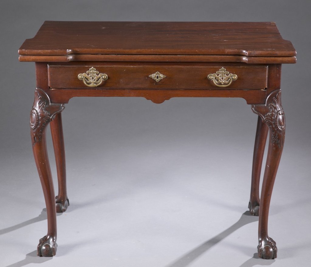 Chippendale revival card table: A Chippendale revival card table. Early 20th c. Incorporating ornate brass pulls, ball and claw feet, carved knees, and gate leg. 29"h x 56"w x 28"d.