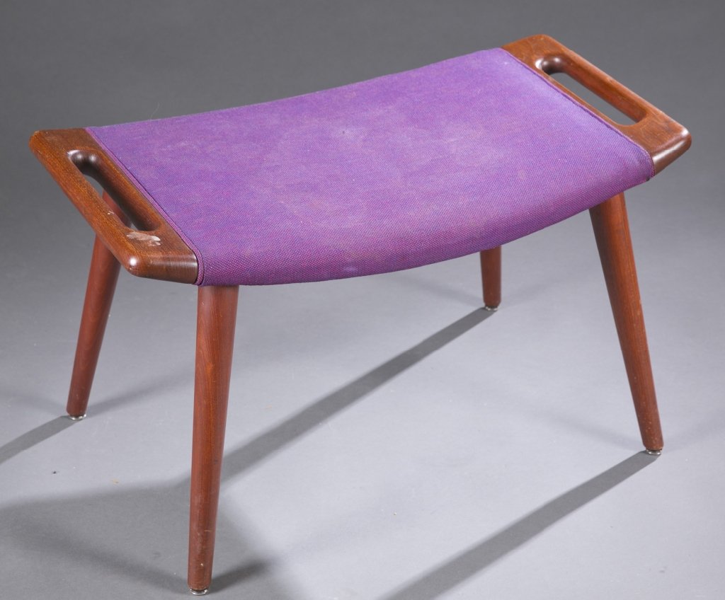 A Hans Wegner ottoman.: A Hans Wegner ottoman. c.1960s. Purple upholstery and teak frame. Round tag for Control furniture makers. 17"h x 27 1/2" x 16".