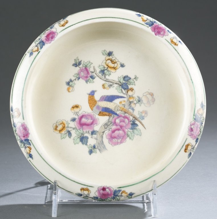 UND low bowl, early with decal decoration.: An UND low bowl, early, with decal design of Asian motifs on a white glaze background. On bottom, UND circular ink stamp in blue. 1 1/2"h x 7 3/4"diam. Publication: Forester, University of North Dakot