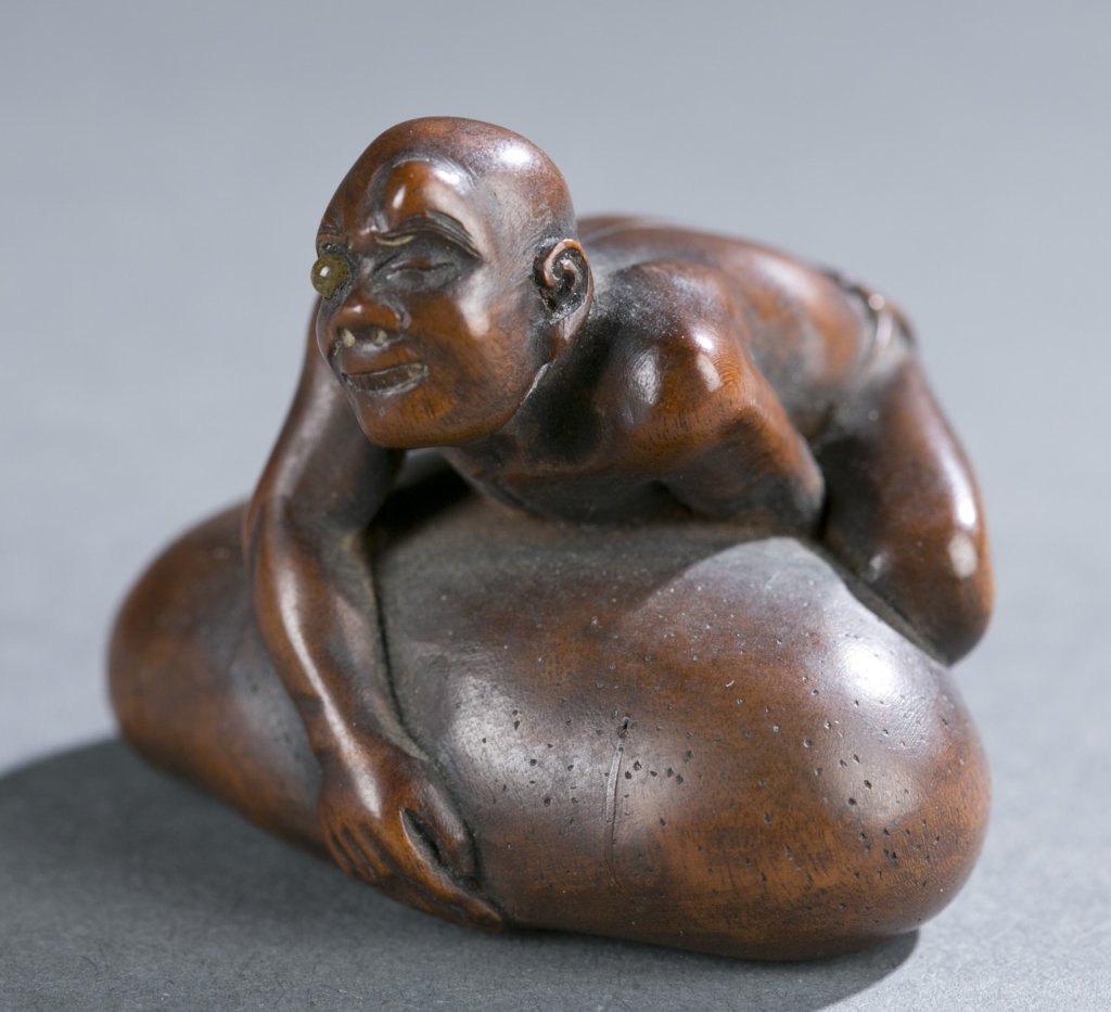 Blind Beggar, lifting Scrotum netsuke: A Japanese wood netuke of blind beggar. 19th century. Beggar with one inlaid eye, bending over trying to lift his engorged scrotum. Collection number "187" in white on bottom. A well carved piece.