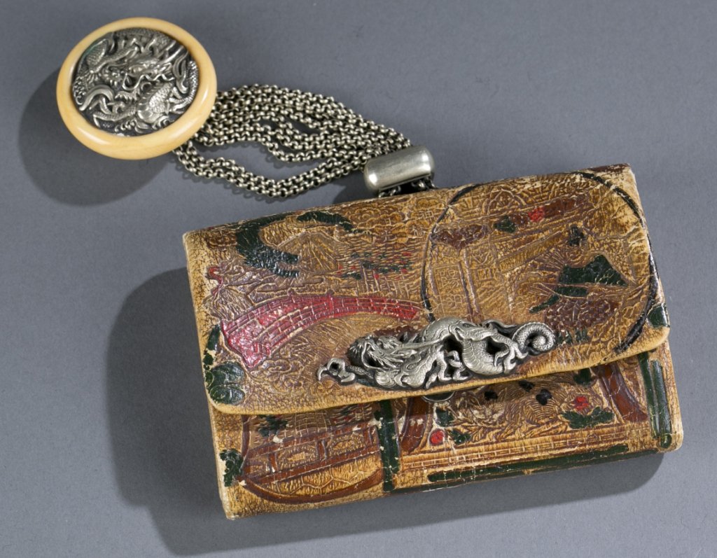 Japanese Ivory/metal manju w/leather tobacco pouch: A Japanese dragon motif Ivory/metal kagamibuta with leather tabako-ire. 19th century. Kagamibuta with metal disk with relief design of dragon with ivory bowl. Leather tobacco pouch with metal dragon c