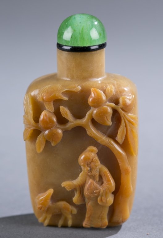 Chinese brown chalcedony snuff bottle: A Chinese brown chalcedony snuff bottle with high relief carved Shoulao under peach tree with deer. C.1750-1860. Rectangular form with concave foot and straight neck Well hollowed. Back with low relie