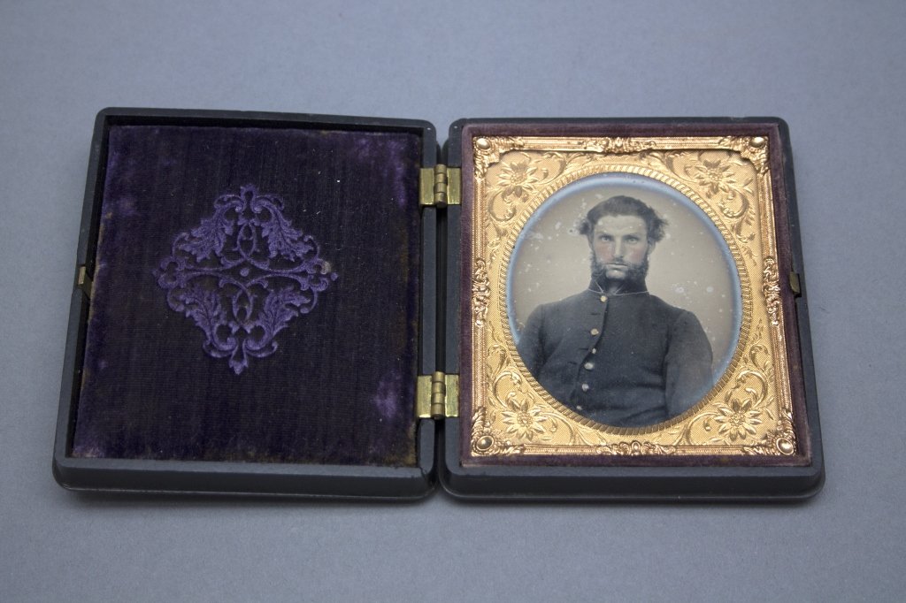 Civil War Soldier in Union Case.: [Civil War/Union Case]. Sixth-plate Ambrotype of Civil War soldier in uniform, w/ hand-coloring to face, in Littlefield, Parsons & Co. Daguerreotype or Union case. Photo w/ slight tarnish ring, slight