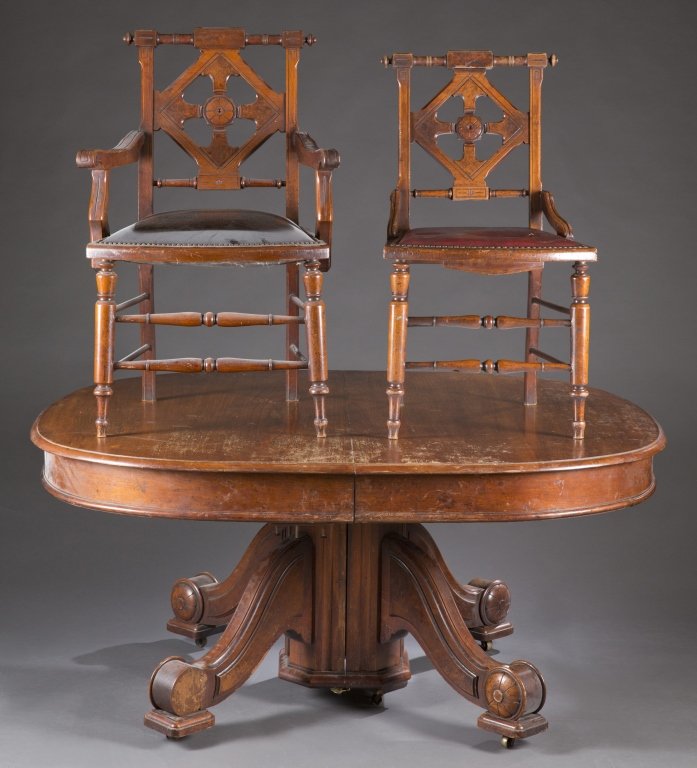 Eastlake/Renaissance Revival dining set, 19th c.: An Eastlake/Renaissance revival dining set, 19th century. American. ++ Solid hardwood dining table with scroll legs terminating in carved flowers on modern casters and 6 leaves. ++ 8 dining chairs: 2