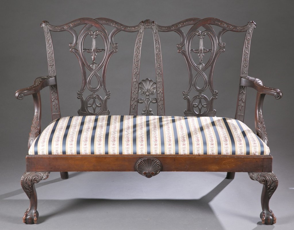 Chippendale Revival Settee: A Chippendale style revival settee. Mid 19th c. Incorporating solid, carved hardwood with shells and floral motifs, pierced splats, ball and claw feet, and modern upholstered slip seat. 36 3/4"h x 50"