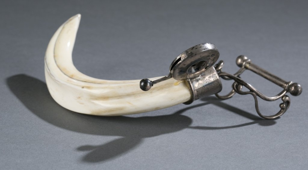 Ivory tusk cigar cutter & holder. c. 19th century.: A 19th century ivory tusk cigar cutter with attached side rest. 6" x 4 1/2". Bidders should be aware of the changing laws regarding commercialization of ivory and other product containing endangered s