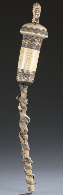 African carved ivory scepter with elephant hide.: An African carved ivory scepter with elephant hide. Having large carved and incised top with male head and thin bottom wrapped with elephant hide attached with nails. 21"L. Bidders should be aware of 