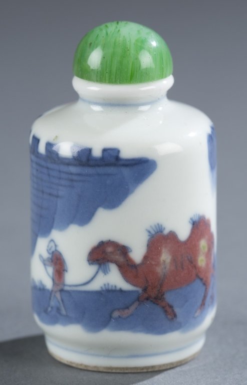 A Chinese squat cylinder porcelain snuff bottle.: A Chinese squat cylinder porcelain snuff bottle. 19th century. With design of camel by a fortress in blue and red under glaze. 1 3/4"h. Provenance: Ex of the G. Mack collection.