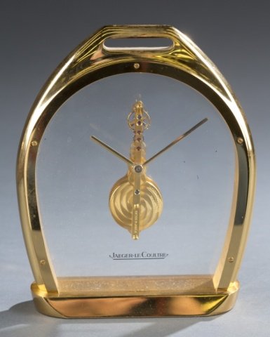 Jaeger-LeCoultre stirrup form clock.: A LeCoultre (Swiss 1833- ) Stirrup form skeleton desk clock in brass with crystal front and back pieces. Marked Sixteen 16 Jewels and on bottom Swiss 3 215 005. 6" x 5 7/8".