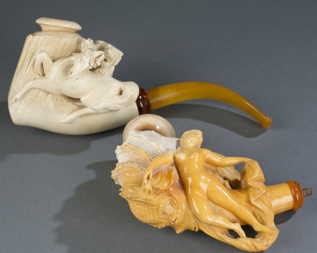 Pair of large Meerschaum pipes.: A pair of carved large Meerschaum pipes. Both in their original case. ++ Pipe depicting a tiger attacking horse. 8". ++ Pipe depicting a large conch shell with a classical nude female. 5 3/4".